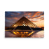 The Louvre Pyramid in a twilight sunset, with it's reflections on a wet surface.
