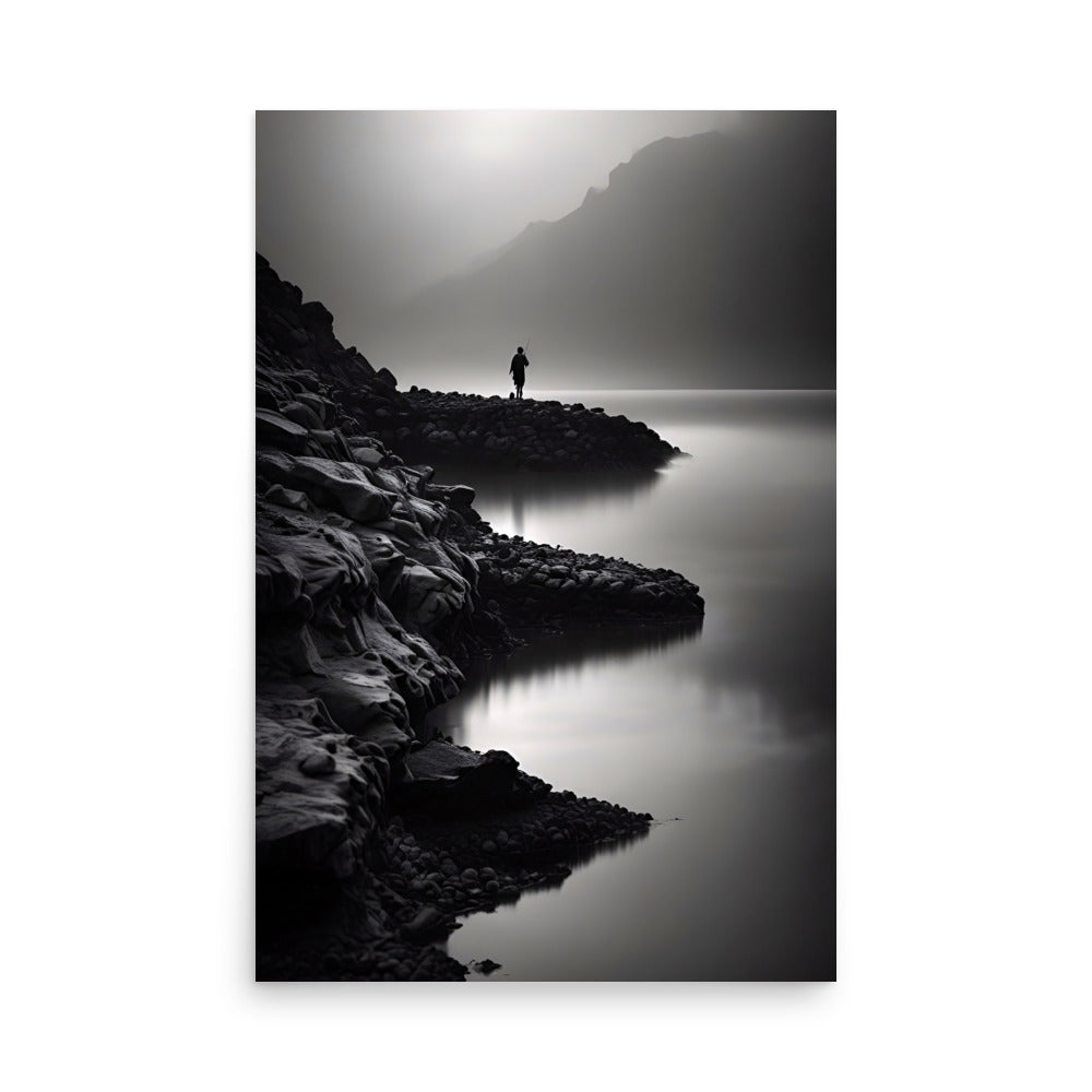 A lone figure stands on rocky shores, fog enveloping the mountainous landscape.
